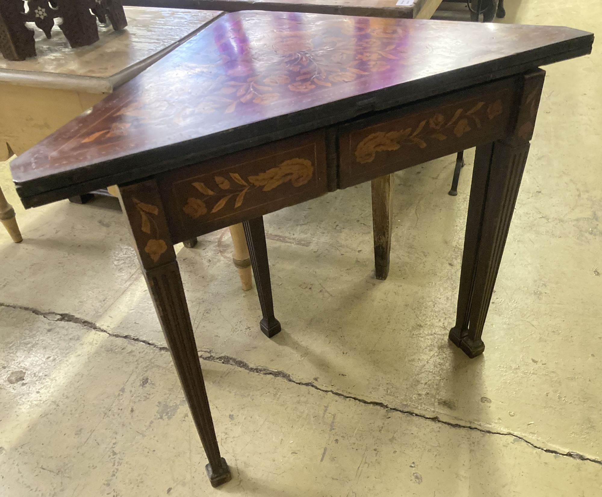 An early 19th century Dutch marquetry inlaid walnut triangular folding tea table, width 93cm, depth 51cm, height 76cm